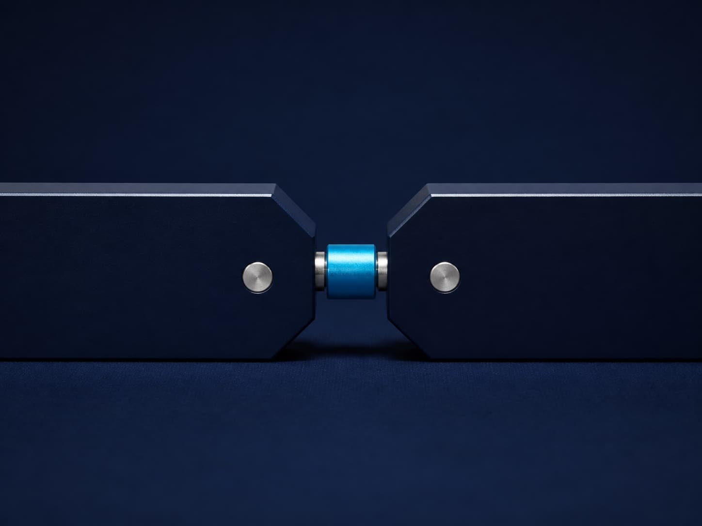 Two precision-made navy forms joined by a cyan connector